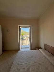 a room with a bed and a door to a balcony at La Bella Vista 10 - Fondi in Fondi
