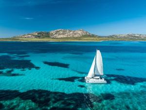 a sailboat floating in the water in the ocean at MyCircle Stintino in Stintino