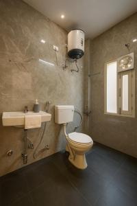 a bathroom with a toilet and a sink at The White Scent-Near Noida Sector34 Metro in Noida