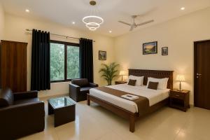 ein Schlafzimmer mit einem Bett, einer Couch und einem Sessel in der Unterkunft The White Scent-Near Noida Sector34 Metro in Noida + 62 Fotos