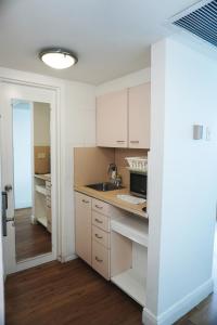 une cuisine avec des armoires blanches et un évier dans l'établissement Shine Suites Studio 11, à Miami Beach