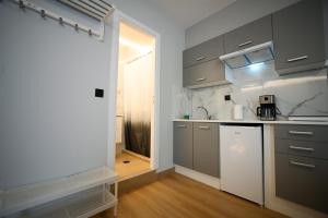 a kitchen with gray cabinets and a white counter top at Family Suite by Zeussuites in Athens +56 photos