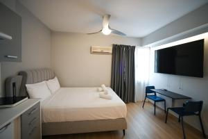 a hotel room with a bed and a desk and a television at Family Suite by Zeussuites in Athens