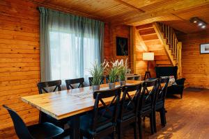 a dining room with a wooden table and chairs at Meldri in Vaidava