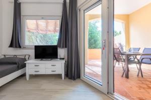 a bedroom with a bed and a sliding glass door at Calarossa Beach House in Isola Rossa