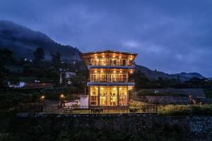 a large building with lights on it at night at Celeste Vista by Chirping Hills in Bhīm Tāl
