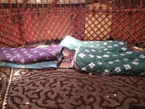 a group of pillows sitting on top of a bed at Anarbek's Yurt Camp in Kol-Suu