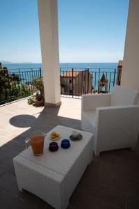 a table and chairs on a balcony with a view of the ocean at Pioppi Apartments in Pioppi