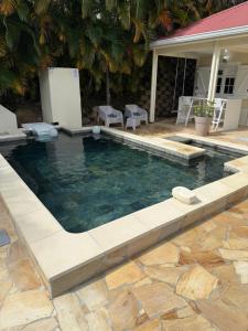a swimming pool in a yard next to a house at Petite Maison Contemporaine in Rivière-Salée