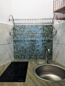 baño con lavabo y pared de azulejos en Uiza de San Pé, en Carloforte