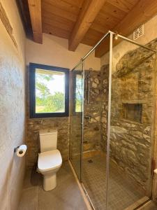a bathroom with a toilet and a glass shower at Mas Ca la Rossa in Girona
