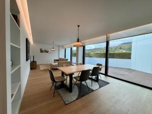 a dining room and living room with a table and chairs at Green Coast Apartments in Capelas