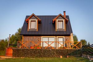 CălăţeleCabana Foxes' Shelter din Beliș, Apuseni的绿色田野上黑色屋顶的房子