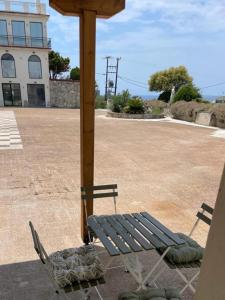 un banc installé sur une terrasse à côté d'un bâtiment dans l'établissement Seaview Oasis and Relaxation, à Paralia Dionisiou 2 autres photos