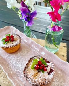 two muffins on a pink plate with flowers and flowers at Glivarpagården in Hammenhög