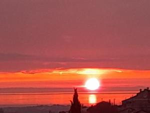 a sunset over the ocean with the sun setting at Villa-Johanna in Kaštelir