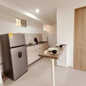 a kitchen with a refrigerator and a table in it at Aviva Sierra 1804 in Santa Marta