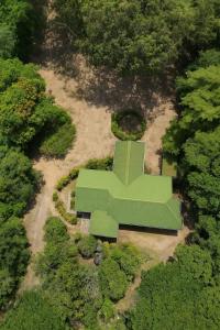 a green building in the middle of a park at Rosewood Bungalow in Bandarawela