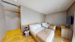 a hotel room with two beds and a flat screen tv at Harbour Boutique Hotel in Shëngjin
