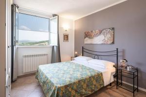 una camera da letto con un letto e una grande finestra di Agriturismo Baia degli Ulivi a Massa Marittima Altre 93 foto