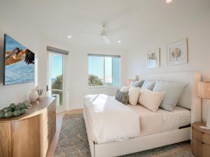 a white bedroom with a couch and windows at Sandrift Villa in Captiva