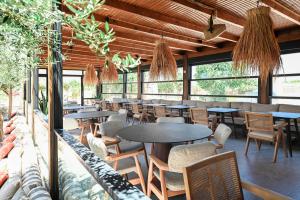 a restaurant with tables and chairs and windows at Ikaros Suites in Amoudara Herakliou