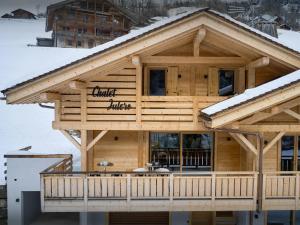 una baita di tronchi con neve sul tetto di Chalet Julero - OVO Network a Le Grand-Bornand