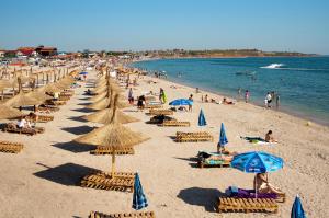 una playa con muchas sillas y sombrillas en Casa Noastra, en Vama Veche