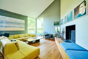 a living room with a yellow couch and a fireplace at La Petite Bruyere De Renaix in Ronse