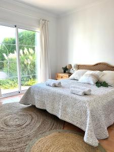 a bedroom with a bed and a large window at Quite villa with private pool in Binibeca in Binibeca