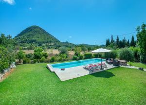 - une piscine avec des chaises et un parasol dans la cour dans l'établissement Owl Booking Villa La Rafal - Luxury Retreat with Mountain Views, à El Port