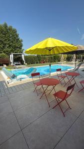a table and chairs with an umbrella next to a pool at B&B casa Belvedere in Tezze sul Brenta