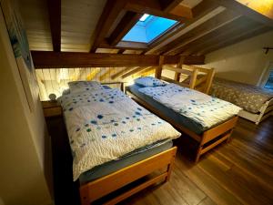 two twin beds in a room with a attic at Vacances Mont-Crosin, Studio chez les Quadeurs in Mont-Crosin