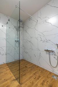 a bathroom with white marble walls and a shower at Giewont View Apartamenty z widokiem Seven & Sauna - Grunwaldzka Krupówki Centrum by RentiloPL in Zakopane +46 photos