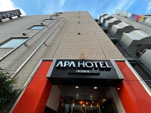 een hotelbord aan de zijkant van een gebouw bij APA Hotel Machidaeki-Higashi in Machida