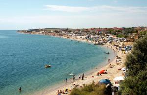 un grupo de personas en una playa con el agua en Casa Noastra, en Vama Veche