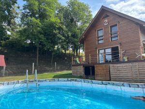 a large swimming pool in front of a house at Woodstock in Krajnik Dolny