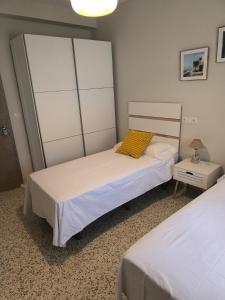 a bedroom with two beds and a night stand at Casacasini 1B in Málaga