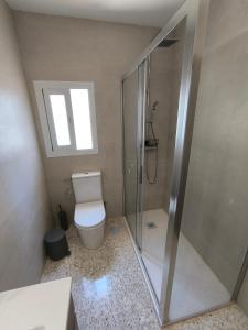 a bathroom with a toilet and a glass shower at Casacasini 1B in Málaga +10 photos