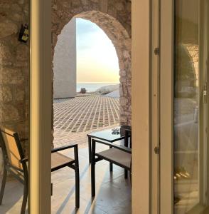 a room with a table and a view of the ocean at Drymades Retreat, Dhërmi in Gjilek