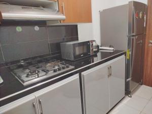 a kitchen with a stove and a microwave at app entre aéroport M5 et nearshore sidi maarouf in Bouskoura +7 photos