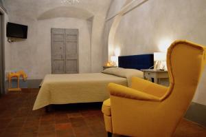 a bedroom with a bed and a yellow chair at Il Viaggiatore 2 in Anagni