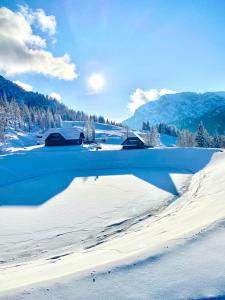 a reflection of a house in a snow covered lake at Byt na svahu Sonnenalpe Nassfeld in Hermagor