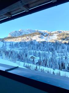 a view of a snowy mountain from a window at Byt na svahu Sonnenalpe Nassfeld in Hermagor +19 photos