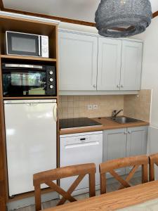 a kitchen with white cabinets and a white refrigerator at DATCHA Joséphine Immobilier in La Salle Les Alpes