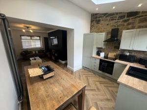 a kitchen with a wooden table in a room at Marine Cottage 1 - With Private Hot Tub in Newbiggin-by-the-Sea +4 photos