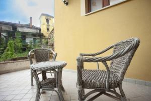 two wicker chairs sitting on a porch next to a building at casa di Papa' in Montefredane