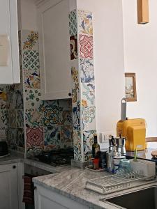 a kitchen with colorful tiles on the walls and a sink at Salerno Eremita Apartment in Salerno