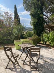 a wooden table and a chair sitting next to a table at Maison Revenu in Jalogny