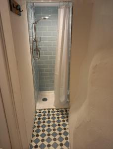 a bathroom with a shower with a tiled floor at Sheila's Cottage in Lynton